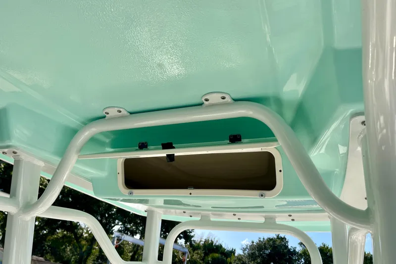 Slide: The Image of 2027 Robalo 226 Cayman boat interior with teal accents and storage compartment. - 15