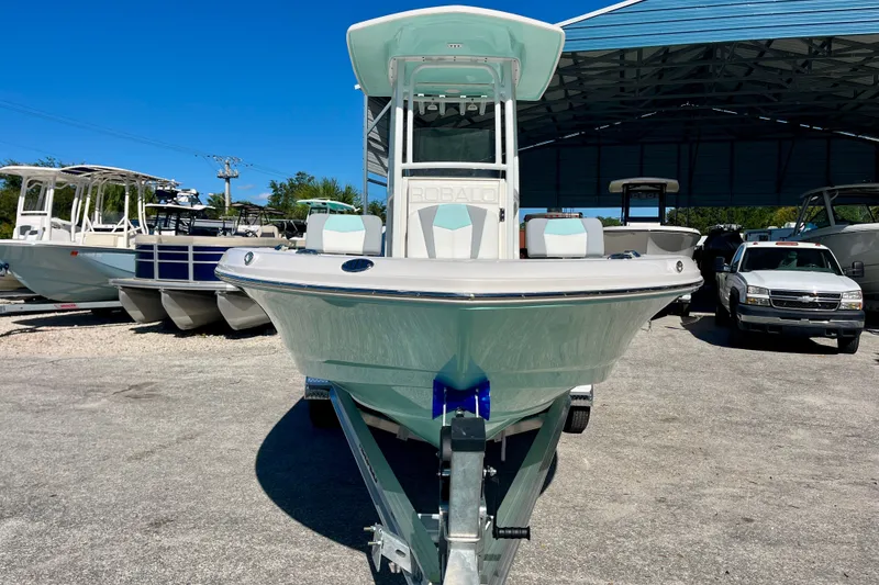 Slide: The Image of 2027 Robalo 226 Cayman boat on trailer in marina under clear blue sky. - 3