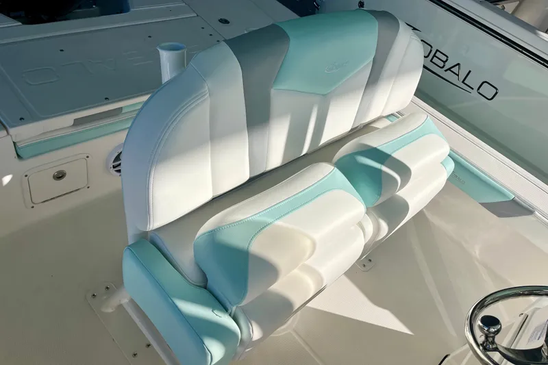 Slide: The Image of 2027 Robalo 226 Cayman boat seat with teal and white upholstery. - 18