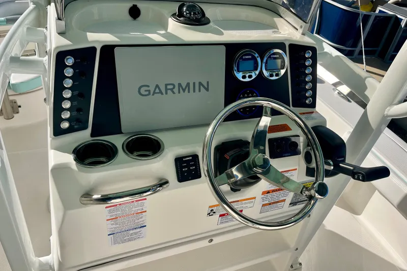 Slide: The Image of 2027 Robalo 226 Cayman boat dashboard with Garmin display and steering wheel. - 17