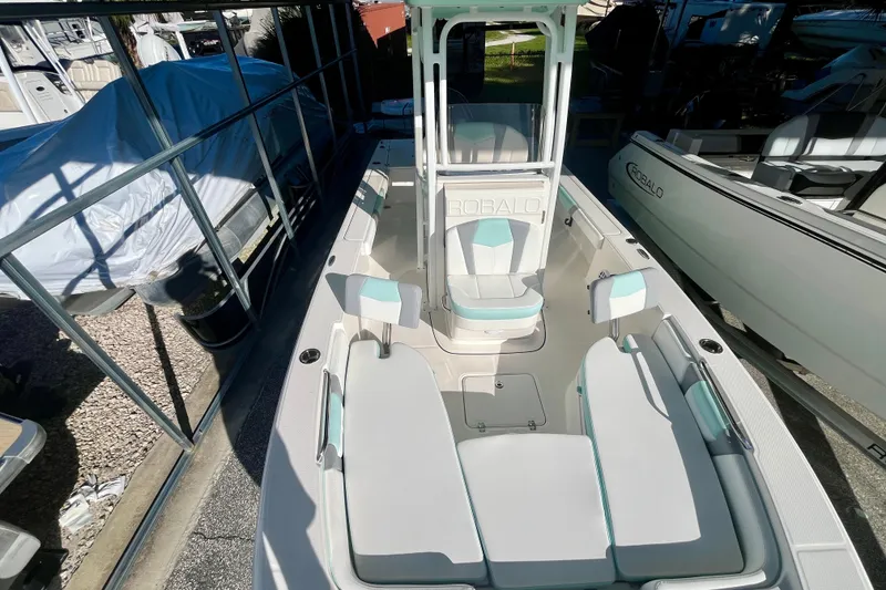 Slide: The Image of 2027 Robalo 226 Cayman boat with spacious seating and sleek design in a showroom. - 26