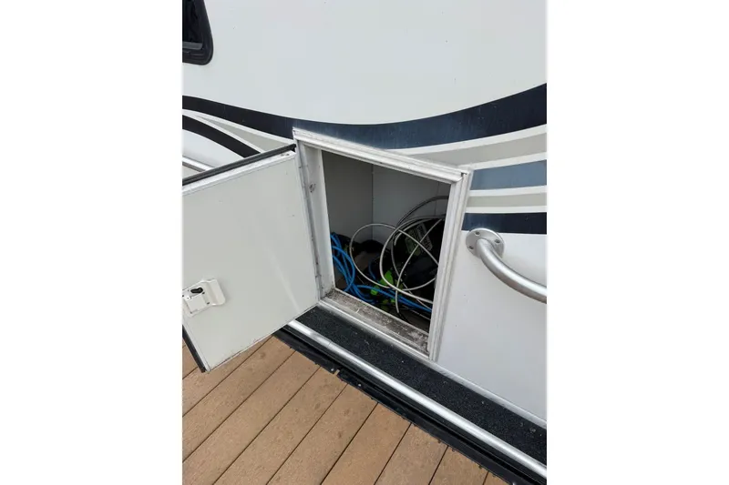 Slide: The Image of Open storage compartment on a 2005 Sumerset 16'6" X 63 houseboat, showing cables inside. - 104