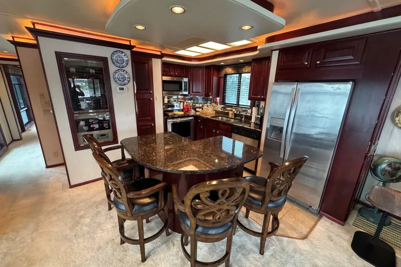 Slide: The Image of Luxurious kitchen in a 2005 Sumerset houseboat, featuring granite countertops and elegant wooden cabinetry. - 50