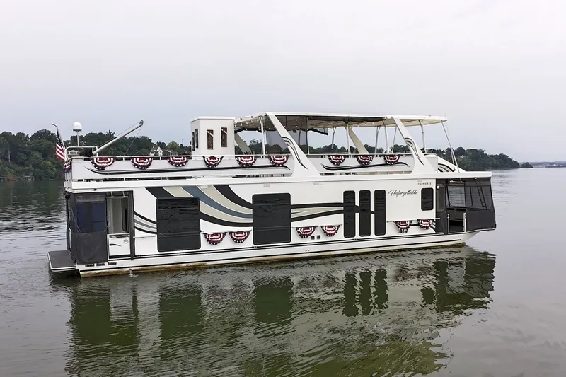 Slide: The Image of 2005 Sumerset houseboat on calm lake, decorated with patriotic banners. - 12