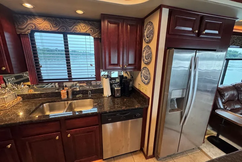 Slide: The Image of Luxurious kitchen in a 2005 Sumerset houseboat with stainless steel appliances and wooden cabinetry. - 57