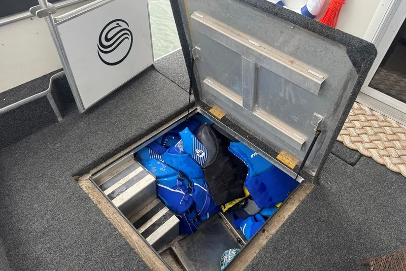 Slide: The Image of Open storage hatch on 2005 Sumerset houseboat, revealing life jackets inside. - 109
