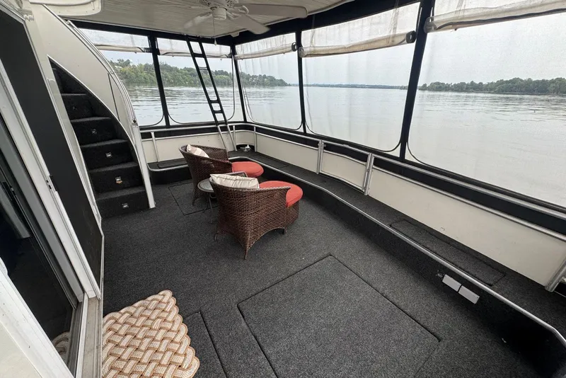 Slide: The Image of Spacious 2005 Sumerset houseboat interior with wicker chairs, carpeted floor, and panoramic water views. - 20