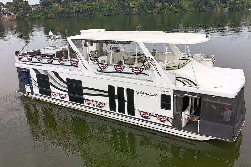 Slide: The Image of 2005 Sumerset 16'6" X 63 houseboat on a calm lake, decorated with festive banners. - 15