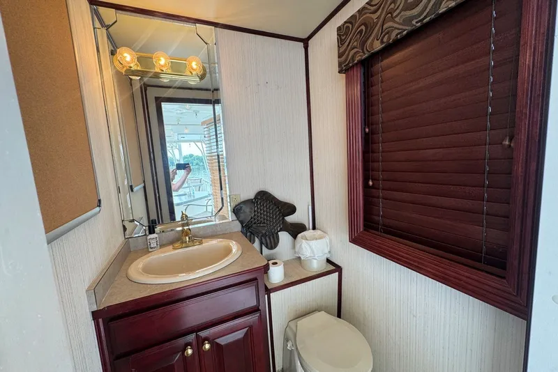 Slide: The Image of Bathroom interior of 2005 Sumerset houseboat, featuring sink, mirror, and wooden blinds. - 39
