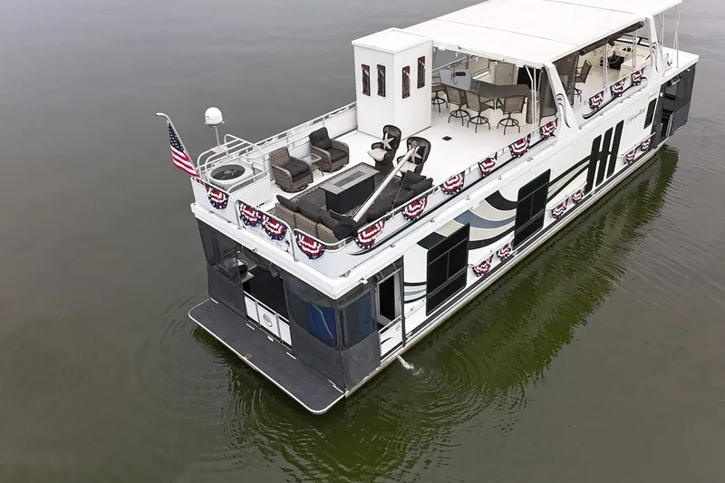 Slide: The Image of 2005 Sumerset 16'6" X 63 houseboat with upper deck seating and American flag decorations. - 11