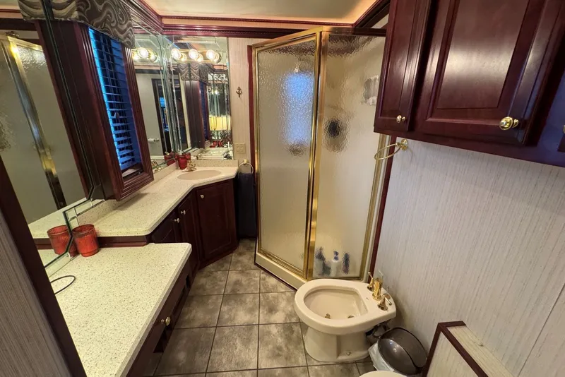 Slide: The Image of Luxurious bathroom in a 2005 Sumerset houseboat, featuring elegant wood cabinetry and a glass shower. - 85