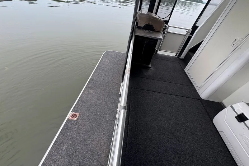 Slide: The Image of 2005 Sumerset houseboat deck with carpeted flooring and railing, overlooking calm water. - 97