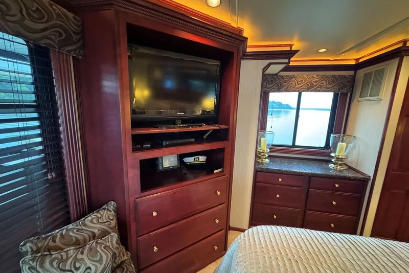 Slide: The Image of Luxurious 2005 Sumerset houseboat interior with TV, elegant wood cabinetry, and scenic window view. - 81