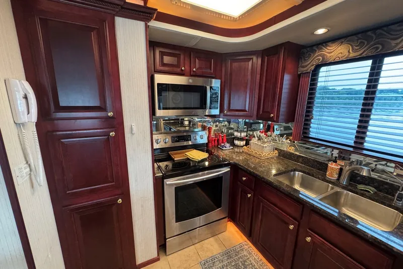 Slide: The Image of Luxurious kitchen in a 2005 Sumerset houseboat with cherry wood cabinets and stainless steel appliances. - 56