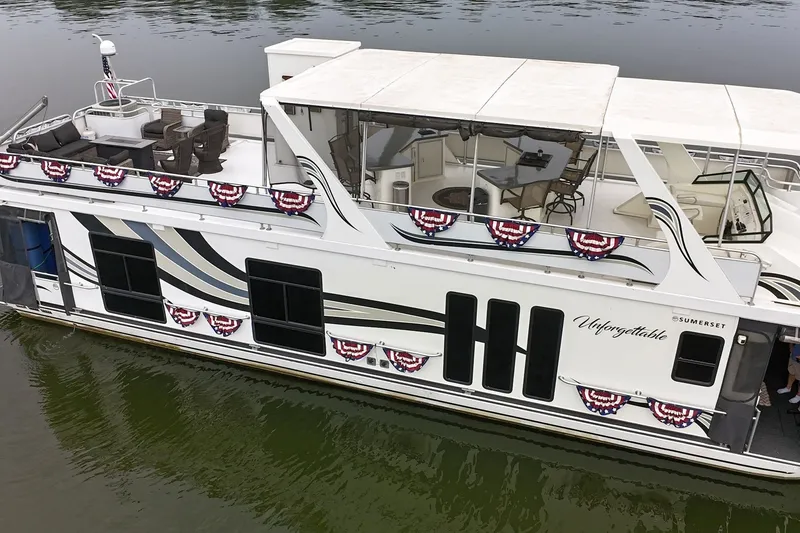 Slide: The Image of 2005 Sumerset houseboat with festive decorations on a calm lake. - 14