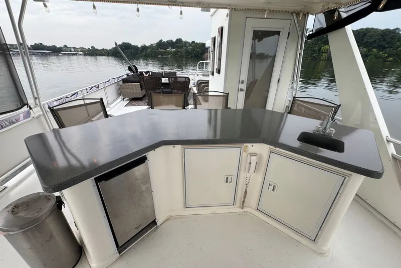 Slide: The Image of Outdoor kitchen on a 2005 Sumerset houseboat with countertop, sink, and seating area. - 31