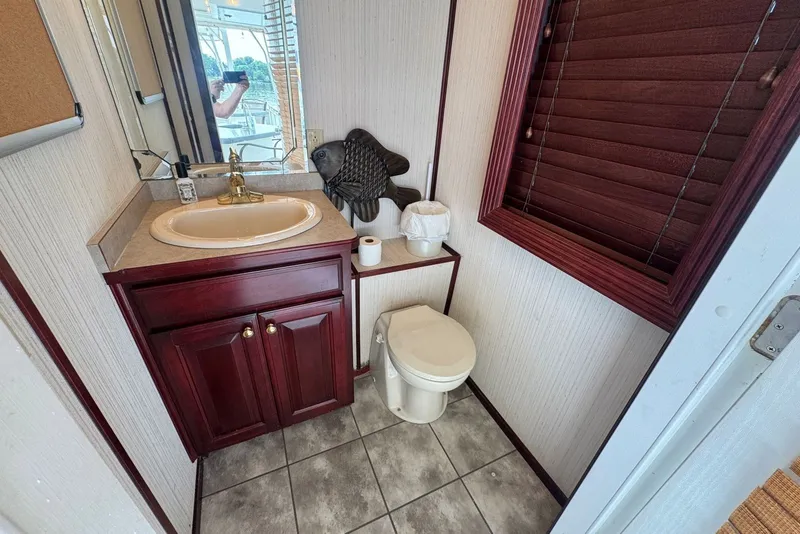 Slide: The Image of Bathroom interior of 2005 Sumerset houseboat with wooden cabinets and decorative fish. - 38