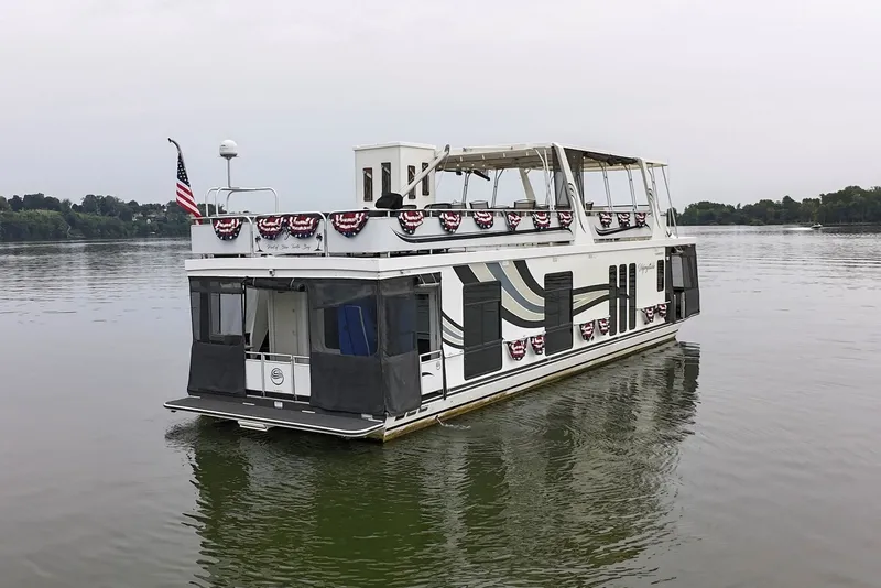 Slide: The Image of 2005 Sumerset 16'6" X 63 houseboat on calm lake, decorated with patriotic bunting. - 10