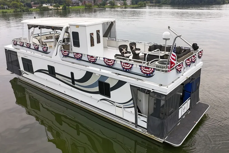Slide: The Image of 2005 Sumerset 16'6" X 63' houseboat decorated with patriotic banners on a calm lake. - 6