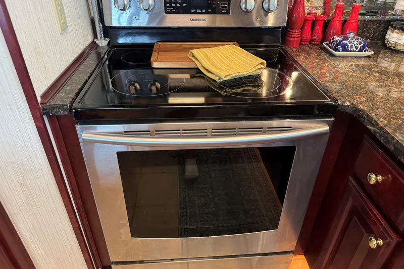 Slide: The Image of Modern kitchen with Samsung stainless steel oven, granite countertops, and red accents. Sumerset 2005 model. - 58