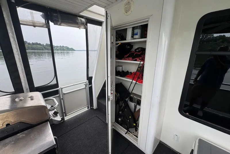 Slide: The Image of Interior view of a 2005 Sumerset houseboat with open storage shelves and fishing gear. - 95