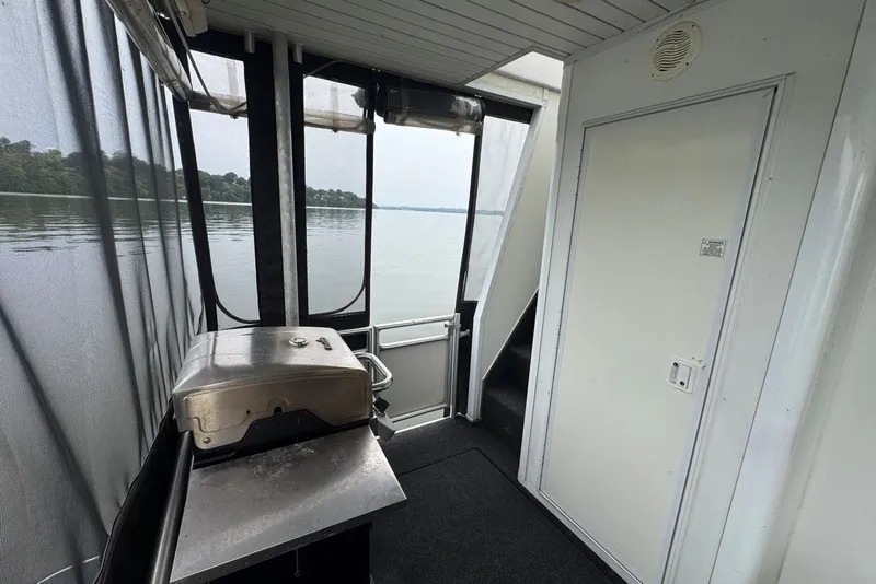 Slide: The Image of Outdoor deck of a 2005 Sumerset houseboat with a grill and lake view. - 93