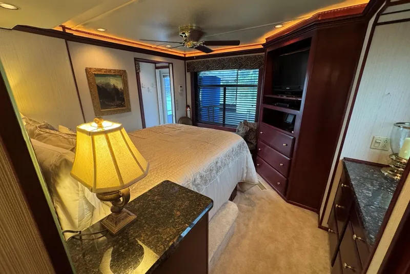 Slide: The Image of Luxurious bedroom interior in a 2005 Sumerset 16'6" X 63 houseboat, featuring elegant wood finishes. - 89
