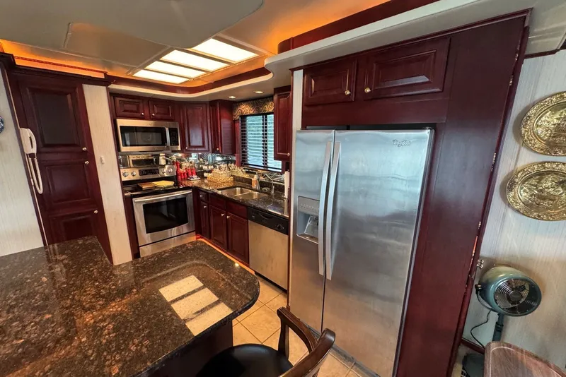 Slide: The Image of Luxurious kitchen in a 2005 Sumerset 16'6" X 63 houseboat with modern appliances and wood cabinetry. - 51