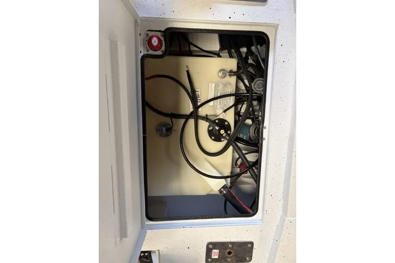 Slide: The Image of Open compartment of 2027 Xpress XR21 Bay boat showing internal wiring and components. - 19