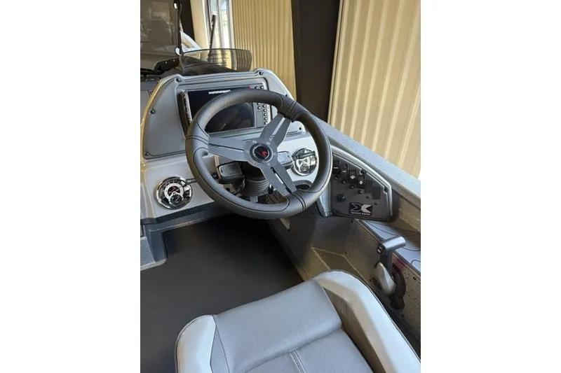 Slide: The Image of 2027 Xpress H20 Crappie boat dashboard with steering wheel and control panel. - 12