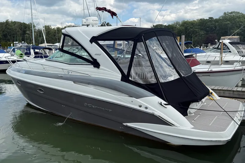 The Image of 2019 Crownline 350 SY yacht docked at marina, featuring sleek design and black canopy. - 0