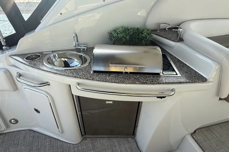 Slide: The Image of 2019 Crownline 350 SY yacht kitchenette with sink, grill, and countertop. - 13