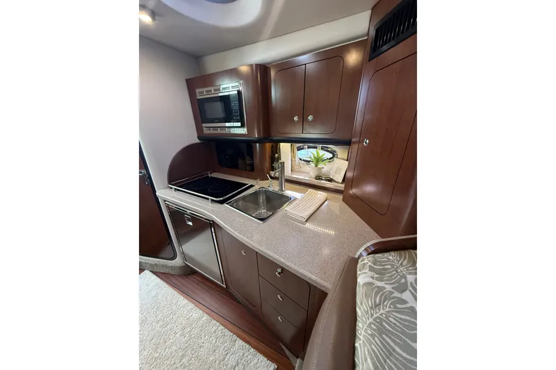 Slide: The Image of Luxurious 2019 Crownline 350 SY yacht kitchen with modern amenities and elegant wood cabinetry. - 19