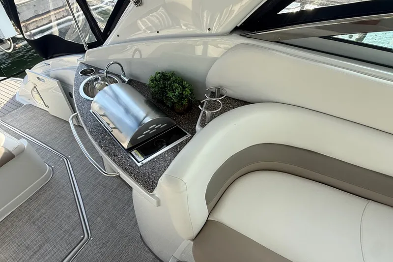 Slide: The Image of 2019 Crownline 350 SY yacht interior with sleek kitchenette and seating area. - 14