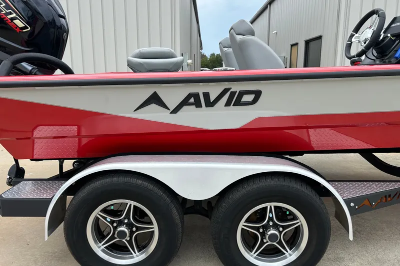 Slide: The Image of 2022 Avid 20 XB boat on trailer, red and white design, parked outdoors. - 32