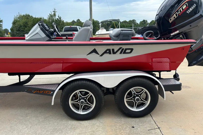 Slide: The Image of 2022 Avid 20 XB boat on trailer with Yamaha engine, parked outdoors. - 35