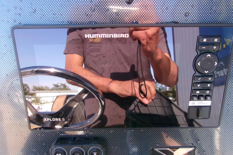 Slide: The Image of Reflection on Xpress XR21 Bay boat dashboard with steering wheel and control panel, 2026 model. - 21