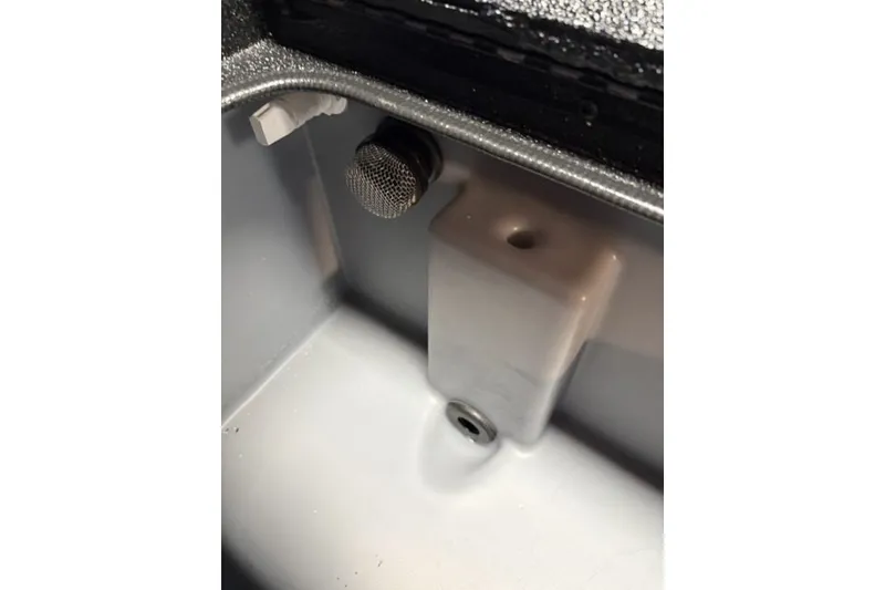 Slide: The Image of Interior view of 2027 Xpress H18 Bass boat compartment with drain and fittings. - 14