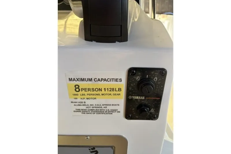 Slide: The Image of 2027 Xpress H20 Bay boat capacity label, 8 persons, 1128 lbs, Yamaha controls visible. - 18