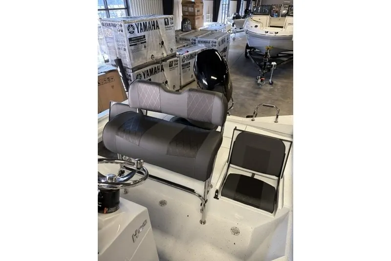 Slide: The Image of 2027 Xpress H20 Bay boat interior with Yamaha engine boxes in showroom. - 19