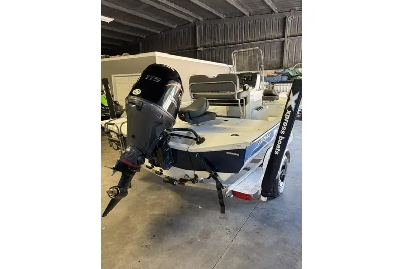 Slide: The Image of 2027 Xpress H20 Bay boat with 115 HP engine in a garage. - 4