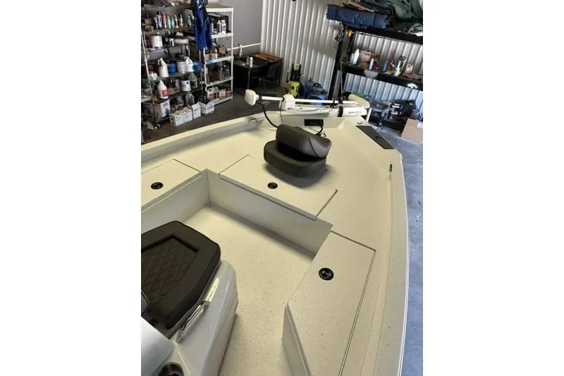 Slide: The Image of 2027 Xpress H20 Bay boat interior in a garage with fishing gear. - 7