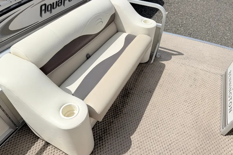 Slide: The Image of 2003 Bennington 205L boat interior with beige seating and cup holders. - 13