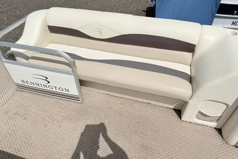 Slide: The Image of 2003 Bennington 205L boat seating with beige and brown upholstery on a textured deck. - 14