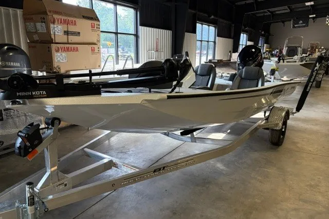 The Image of 2027 Xpress H18 Bass boat on trailer in showroom, featuring Minn Kota motor. - 1