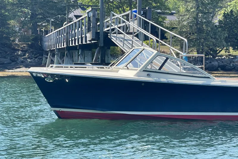 Slide: The Image of 2022 Rossiter 20 boat docked near a wooden pier, surrounded by lush greenery. - 13