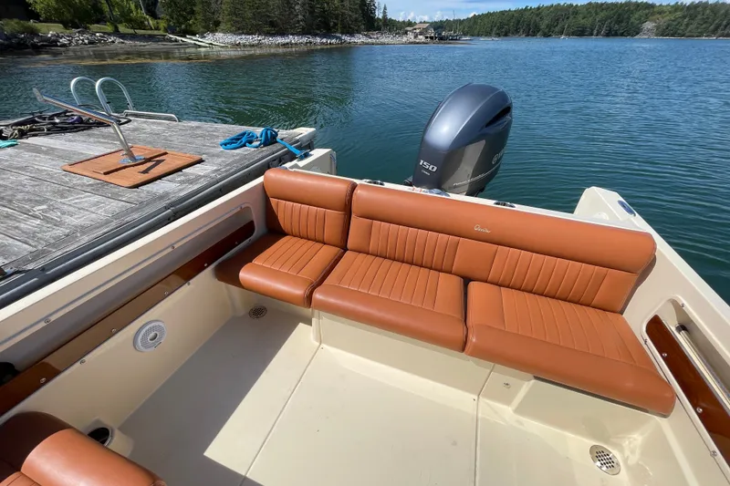 Slide: The Image of 2022 Rossiter 20 boat with tan leather seating, docked by a serene lake. - 29