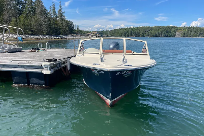Slide: The Image of 2022 Rossiter 20 boat docked on a serene lake with forested shoreline. - 16