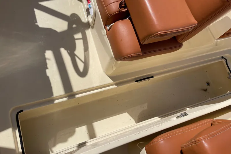 Slide: The Image of 2022 Rossiter 20 boat interior with tan leather seats and storage compartment. - 39