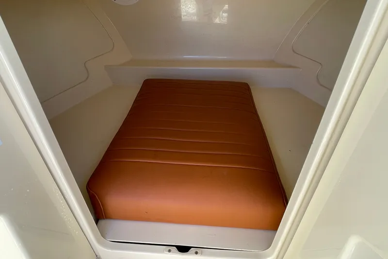Slide: The Image of Cozy cabin interior of 2022 Rossiter 20 boat with brown cushioned seating. - 50
